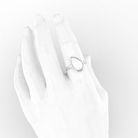 Pear bezel breastmilk ring in 18K white gold on a slim band, worn on a hand